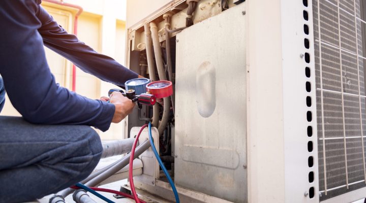 HVAC technician performing a full system inspection on a heat pump checking refrigerant and electrical connections